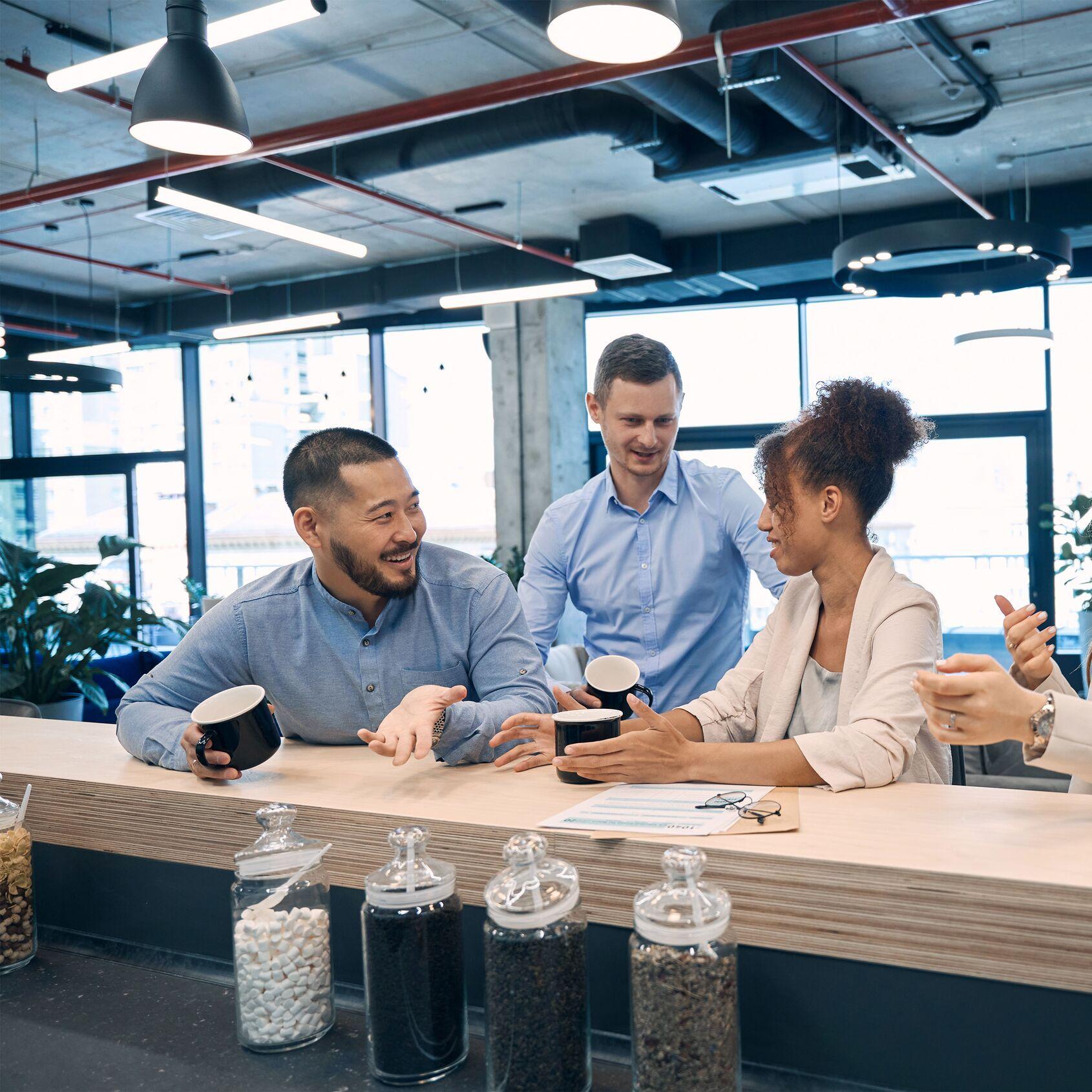 Workplace colleagues engaged in discussion over coffee