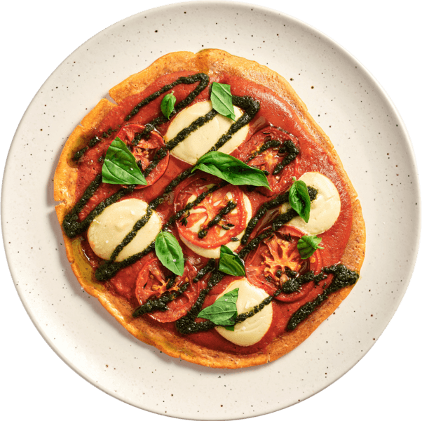 Plant-forward gluten free dough with marinara, vegan mozzarella,  fried basil leaves, oven dried tomatoes, balsamic drizzle.