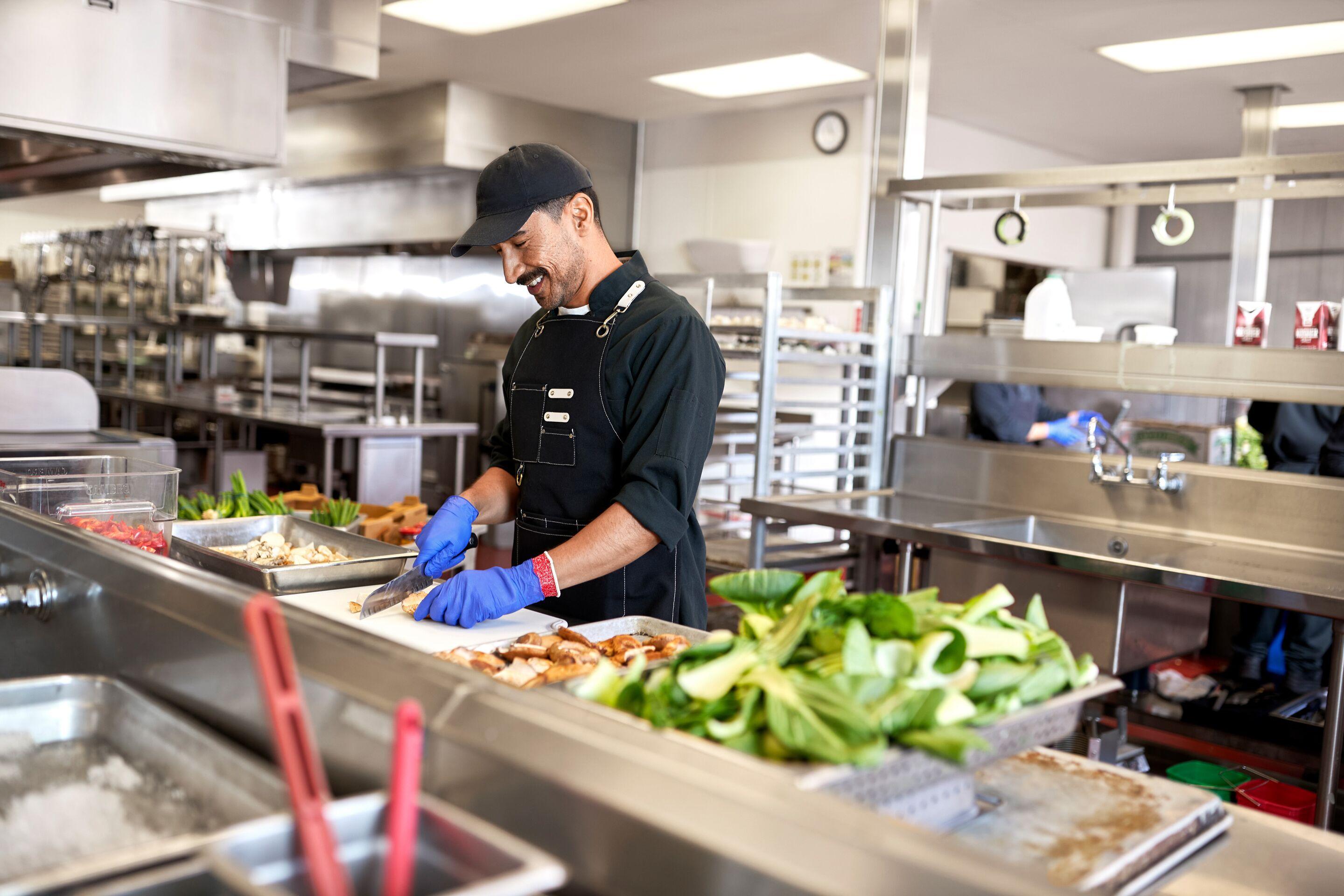 Prep cook cutting vegetables in a commercial kitchen