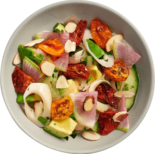 Hearts Palm Salad in reusable dish celebrates  local seasonal ingredients like tomato, red onion, avocado, almonds and herbs. 