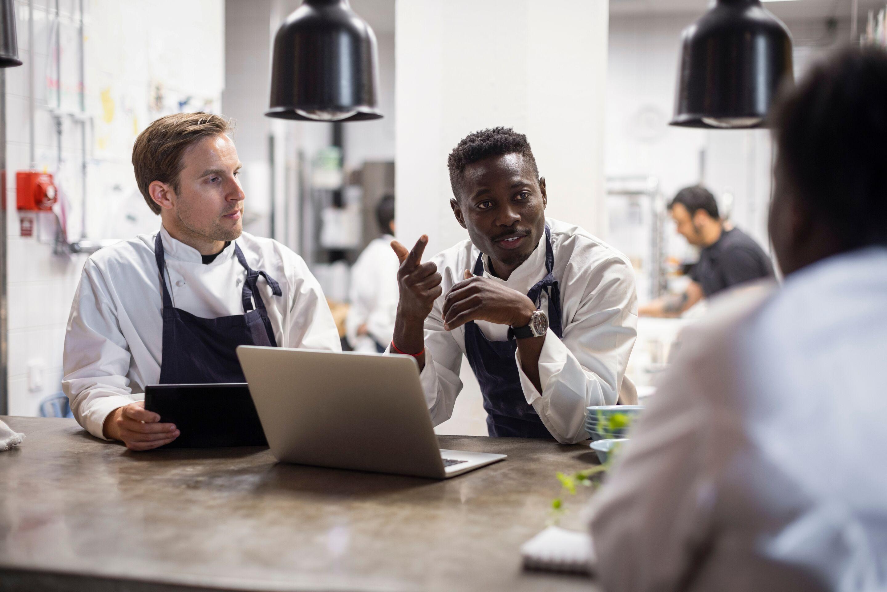 Diverse chefs planning menu in kitchen