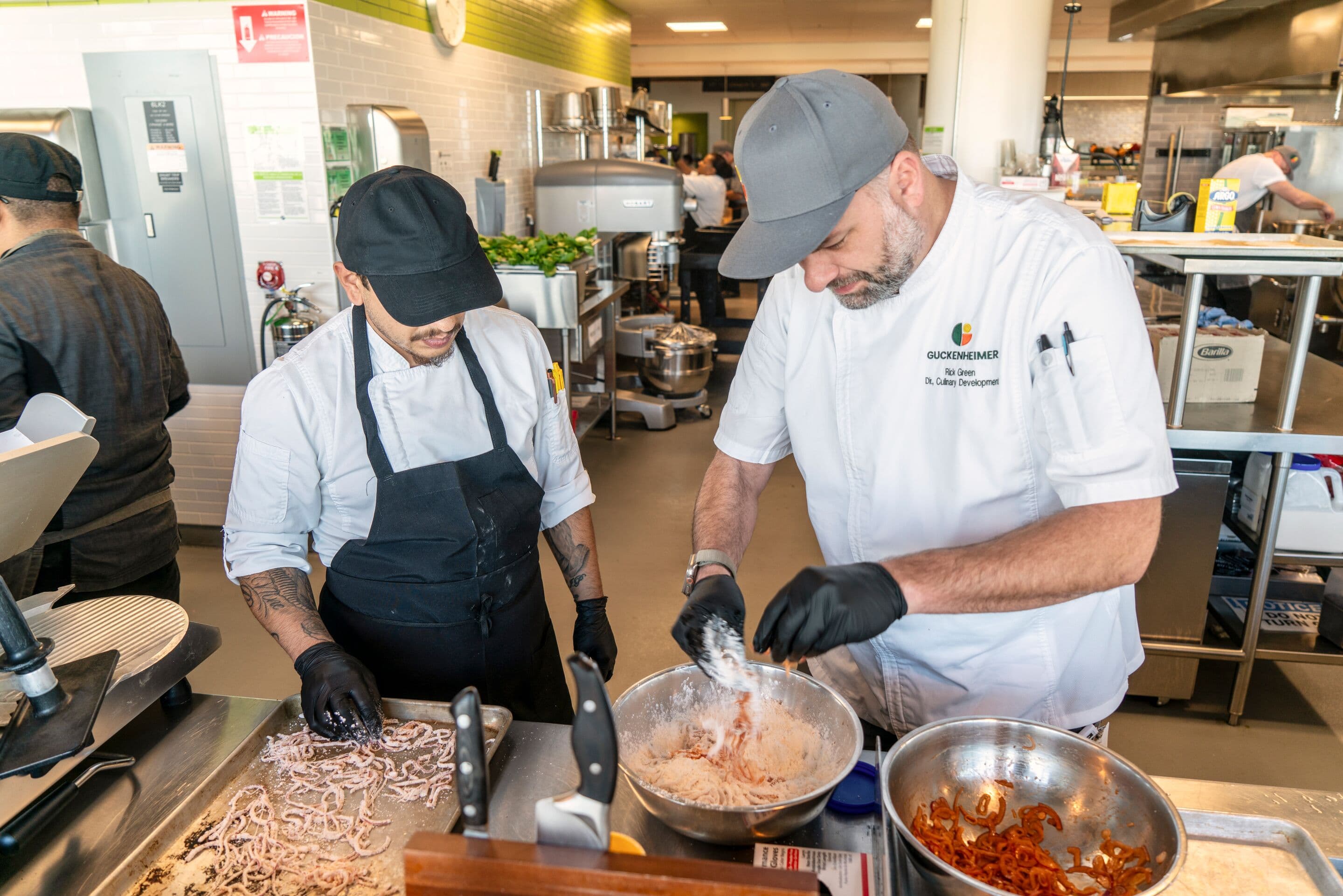 A chef director engages with the team and discusses a new culinary technique that enhances flavor and sustainability.