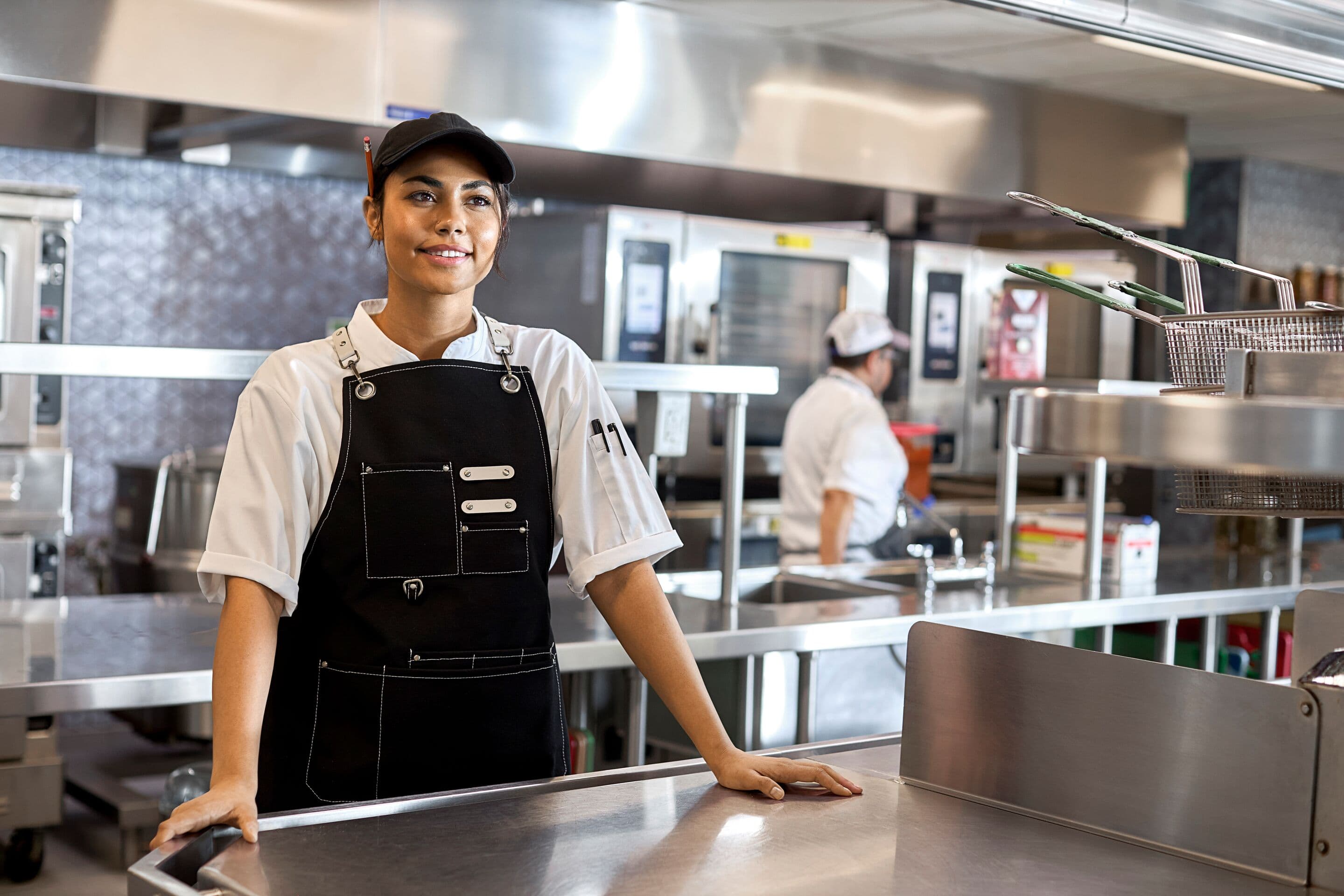 A female chef in a vibrant kitchen, thrives in an environment that prioritizes health, well-being and culinary excellence.